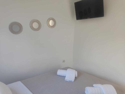 um quarto branco com uma cama e uma televisão de ecrã plano em Irini Apartment em Agios Nikolaos