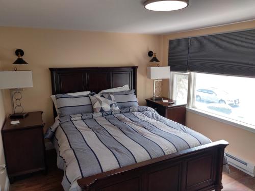 a bedroom with a bed with pillows and a window at Maple Leaf Lodge in Schroon Lake