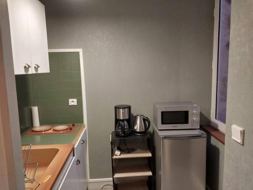 una pequeña cocina con fregadero y microondas en studio hyper centre, wifi,, en La Châtre