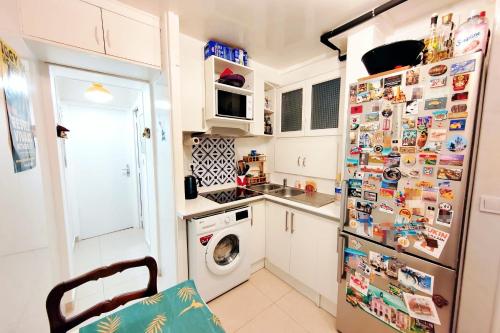 een keuken met een koelkast bedekt met magneten bij Charming 36m2 Apt in Parijs