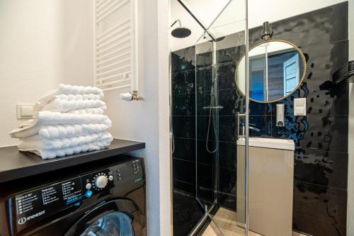 a bathroom with a washing machine and a mirror at Hanza Tower Luxury in Szczecin