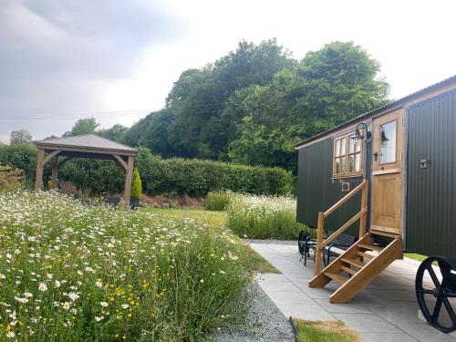 a tiny house and a gazebo in a garden at Woody's Retreat in Bolton by Bowland