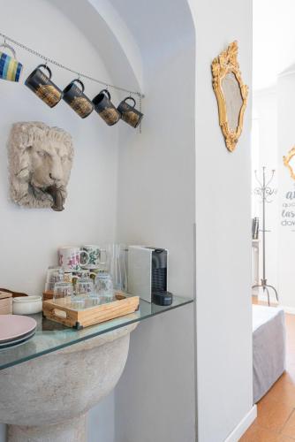 a room with a counter with glasses and a lion on the wall at Casa di Sofia Città Alta in Bergamo