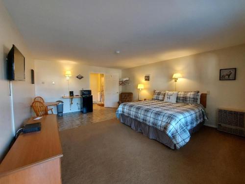 Habitación de hotel con cama y escritorio en Maple Leaf Lodge en Schroon Lake