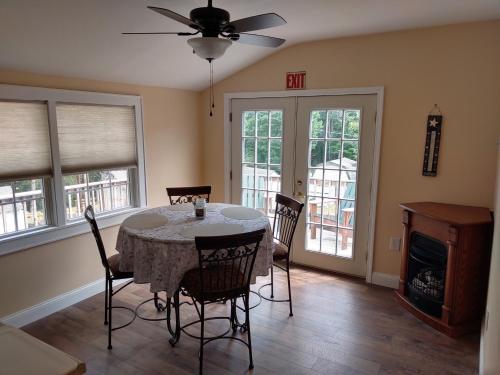 a dining room with a table and chairs and windows at Maple Leaf Lodge in Schroon Lake