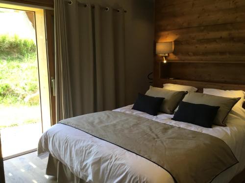 Un dormitorio con una cama grande y una ventana en Chalet du Feug, en Combloux
