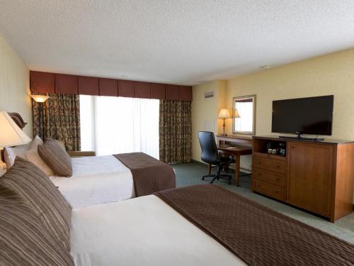 a hotel room with two beds and a flat screen tv at Red Lion Hotel Coos Bay in Coos Bay