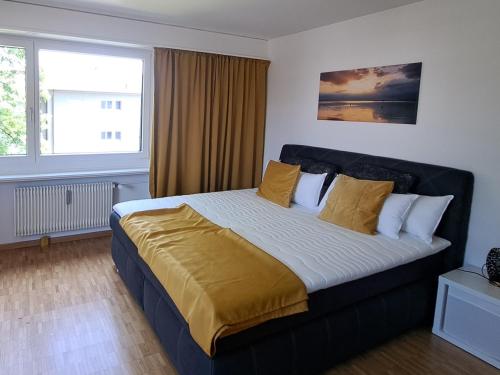 een slaapkamer met een groot bed met gele kussens bij goldenes 1-Zimmer-Appartement Kreuzlingen in Kreuzlingen