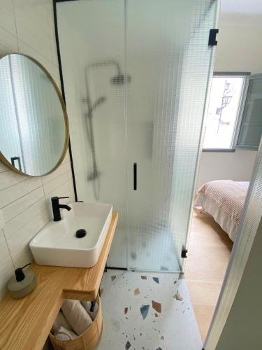 a bathroom with a sink and a shower with a mirror at La Puebla Rooms in Teror
