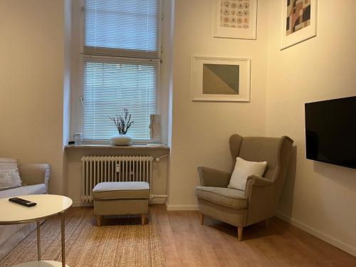 een woonkamer met een bank, een stoel en een tv bij Central-City-Apartment - Innenstadt Wuppertal in Wuppertal