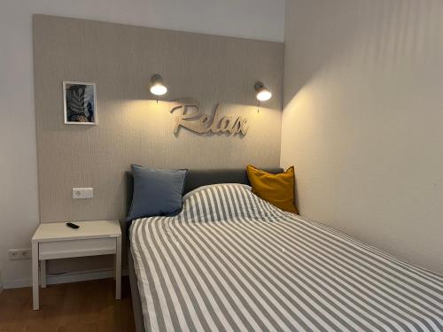 Un dormitorio con una cama y un cartel que diga "relájate" en Central-City-Apartment - Innenstadt Wuppertal en Wuppertal