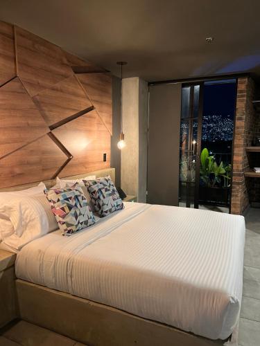 a bedroom with a large bed and a large window at Los Patios Cool Living in Medellín