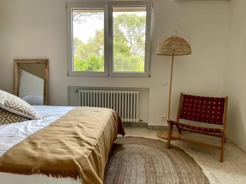 une chambre avec un lit, une chaise et une lampe dans l'établissement Villa Aloes - proche des plages, à Saint-Raphaël
