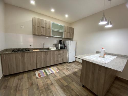 a kitchen with wooden cabinets and a white refrigerator at Taroba Apart in Puerto Iguazú
