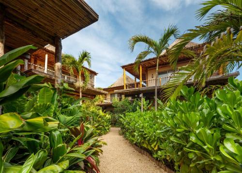 a pathway leading to a resort with trees and plants at Hotel Shibari - Restaurant & Cenote Club in Tulum