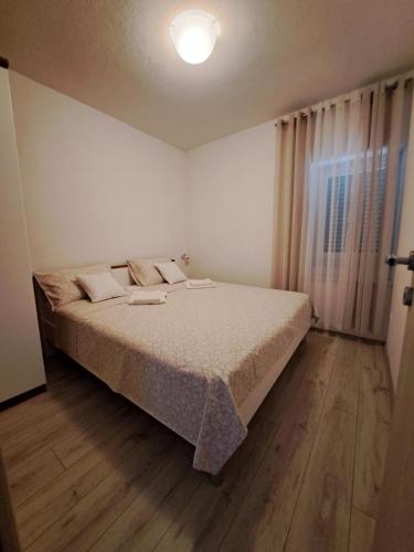 ein Schlafzimmer mit einem Bett und einem großen Fenster in der Unterkunft Kuća za odmor Luka&Luce in Vukšić