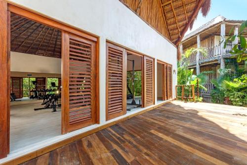 an open porch with wooden shutters on a house at Hotel Shibari - Restaurant & Cenote Club in Tulum