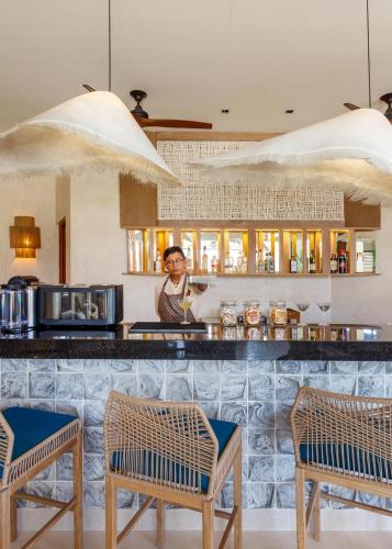a person standing behind a counter in a kitchen at Hotel Shibari - Restaurant & Cenote Club in Tulum