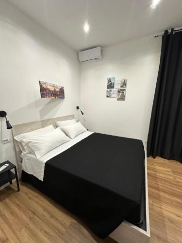 een slaapkamer met een zwart-wit bed en een televisie bij Moderno appartamento Cornelia-San Pietro con Giardino in Rome