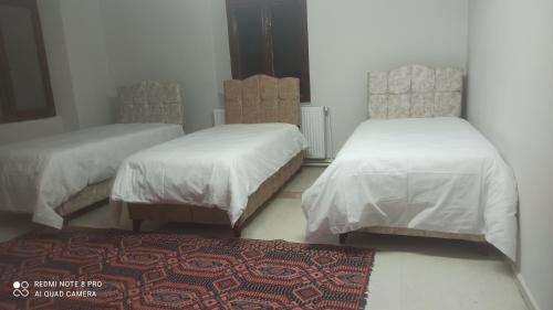 a room with two beds and a rug and a rug at Hamza malikhane (Hane) in Trabzon
