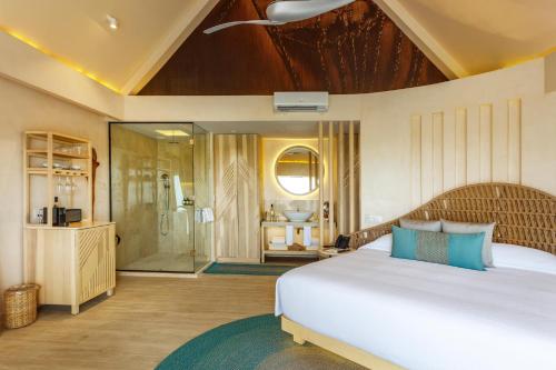 a bedroom with a large bed and a bathroom at Hotel Shibari - Restaurant & Cenote Club in Tulum