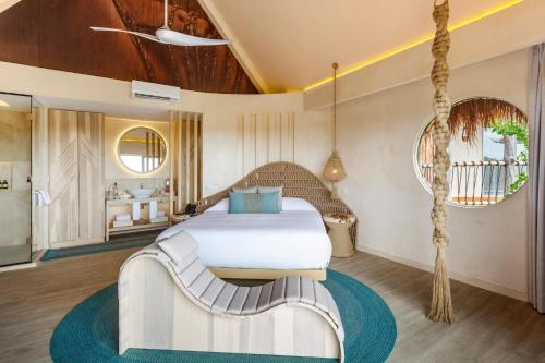 a bedroom with a white bed and a swing at Hotel Shibari - Restaurant & Cenote Club in Tulum