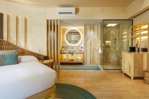 a bedroom with a bed and a bathroom with a shower at Hotel Shibari - Restaurant & Cenote Club in Tulum
