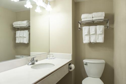 a bathroom with a sink and a toilet and a mirror at Travelodge by Wyndham Monterey Bay in Monterey