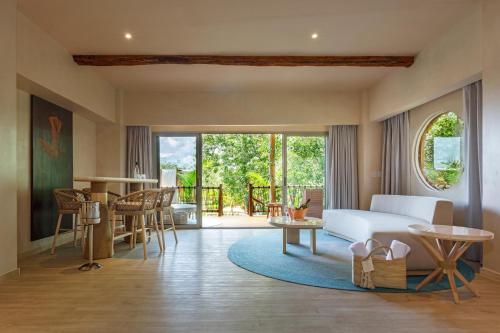 圖盧姆的住宿－Hotel Shibari - Restaurant & Cenote Club，一间卧室配有一张床,客厅配有桌子