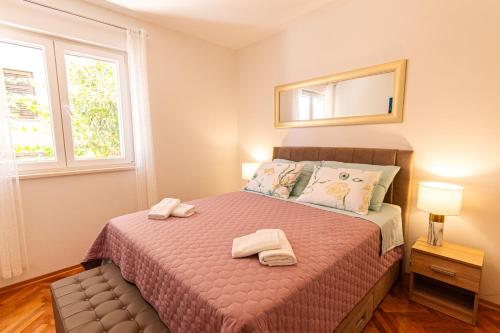 1 dormitorio con 1 cama con 2 toallas en Stylish apt Marta, private parking,BBQ in Stobreč en Stobreč
