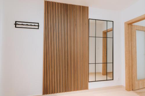 a wooden partition in a room with a mirror at Apartmán 25 Karlova Studánka in Karlova Studánka
