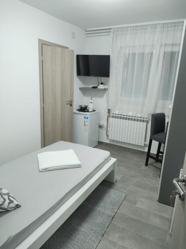 um quarto branco com uma mesa e uma cadeira em Happy room em Karlovac
