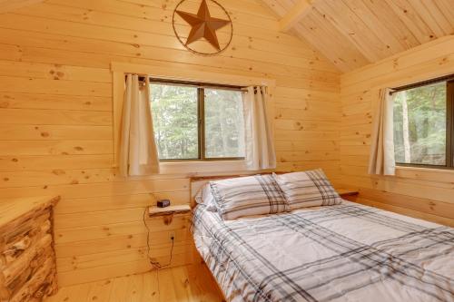 ein Schlafzimmer mit einem Bett in einem Blockhaus in der Unterkunft Tranquil Middlebury Center Cabin with Mountain Views 