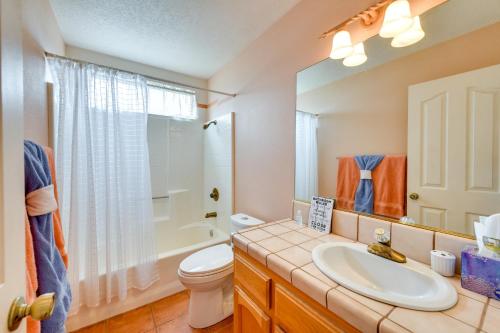 uma casa de banho com um lavatório, um WC e um espelho. em Rural California Getaway with Private Hot Tub em Pioneertown