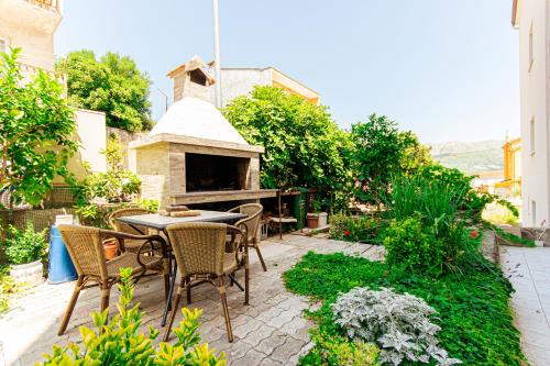 a patio with a table and chairs and a fireplace at Stylish apt Marta, private parking,BBQ in Stobreč in Stobreč
