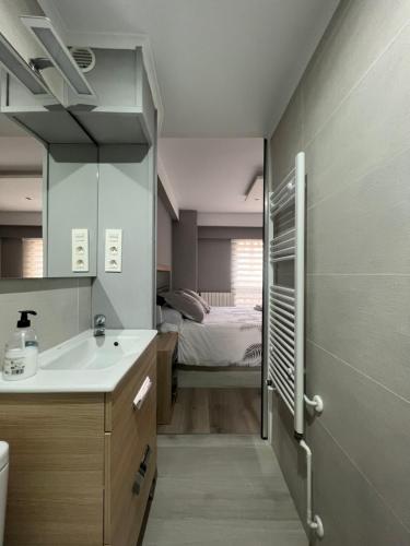 ein Badezimmer mit Waschbecken und ein Bett in einem Zimmer in der Unterkunft Belle Maison VUT-LE-779 in León