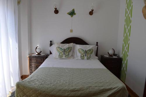 Un dormitorio con una cama con almohadas de mariposa. en OrlaBela, en Manta Rota