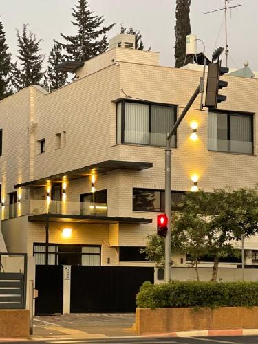 a red traffic light in front of a building at Rokah Luxury Hotel at Ramat HaHayal in Tel Aviv