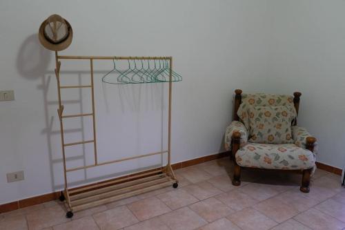 a room with a chair and a shelf and a clock at Comodo appartamento a Crotone in Crotone