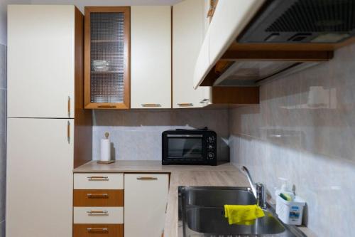 a small kitchen with a sink and a microwave at Comodo appartamento a Crotone in Crotone