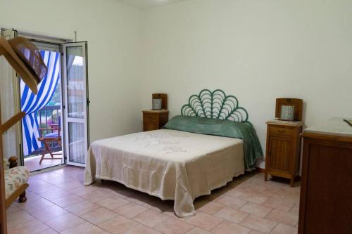 een slaapkamer met een bed en een deur naar een balkon bij Comodo appartamento a Crotone in Crotone