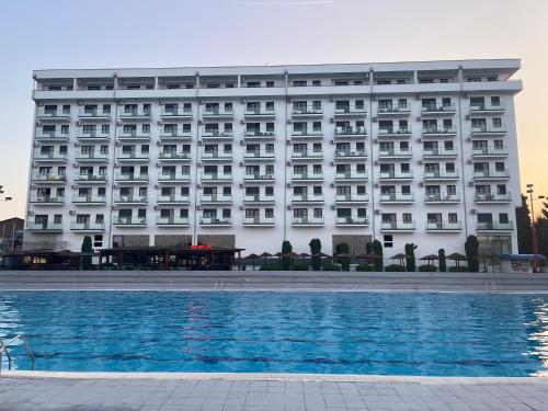 un hotel con piscina frente a él en R Lux Apartman Jagodina Akva Park en Jagodina