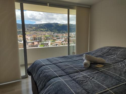 - une chambre avec un lit et une grande fenêtre dans l'établissement Hermoso Apartamento frente al lago, à Paipa