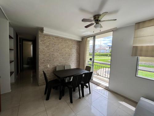 een eetkamer met een tafel en stoelen en een raam bij Espectacular apartamento Conjunto Piedemonte in Villavicencio