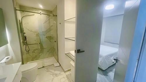 a white bathroom with a shower and a toilet at Cana Rock Star Pool View Whith BBQ in Punta Cana