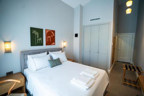 a bedroom with a white bed with two towels on it at Zena Hotel Alaçatı Adults Only in Alacati