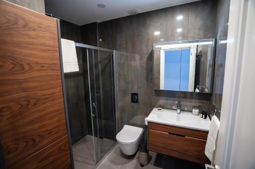 a bathroom with a shower and a toilet and a sink at Zena Hotel Alaçatı Adults Only in Alacati