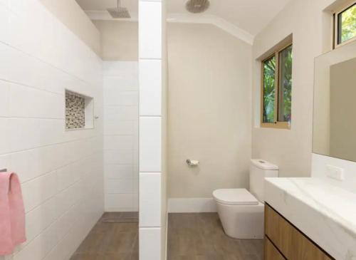 bagno bianco con servizi igienici e lavandino di Villa within walking distance of cable beach Australia a Cable Beach