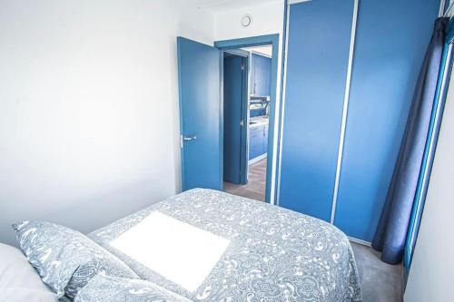 a bedroom with a bed and a blue wall at Apartamento flotante Unico C15A01 in Santander