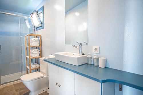 bagno blu con lavandino e servizi igienici di Apartamento flotante. Unico a Santander